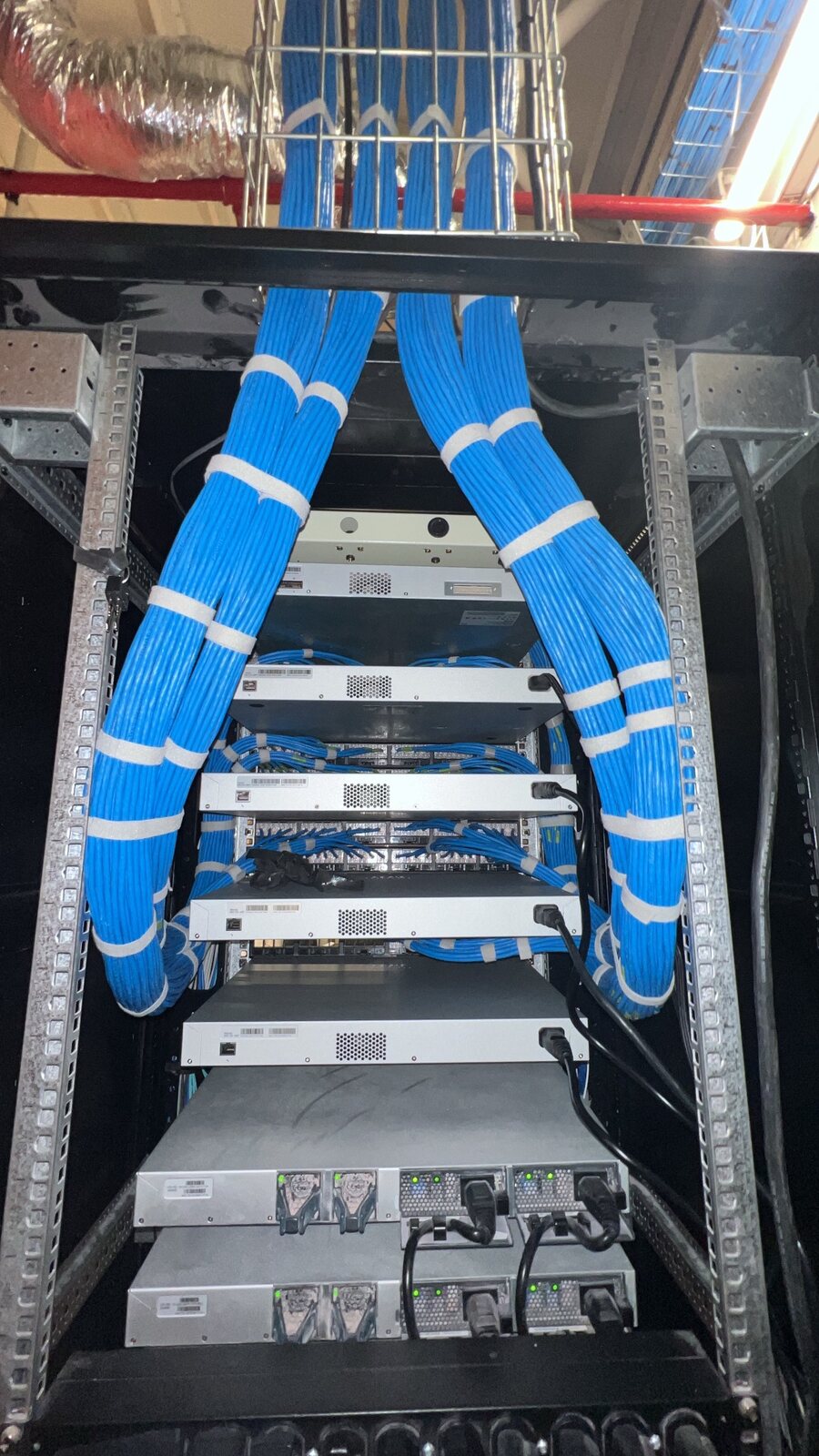 Detalle de cableado estructurado azul organizado dentro de un rack
